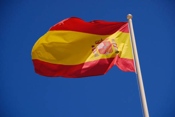 istock Flag of Spain against a blue sky 1027599978