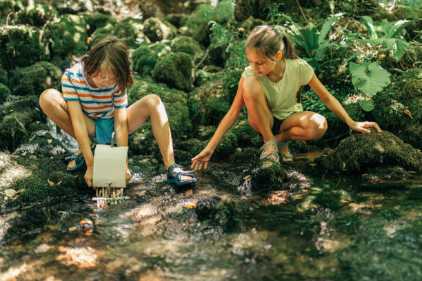 istock Children playing with boat on river 1027620138