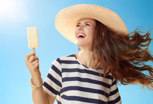 istock smiling woman with ice cream on stick looking at copy space 1027624196