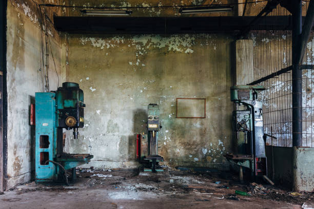 istock Old rusty industrial drilling machine tools in abandoned factory workshop looks like robots 1027624882