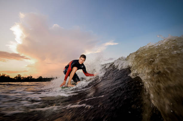 istock Active male wakeboarder riding on the one knee on the board 1027633062