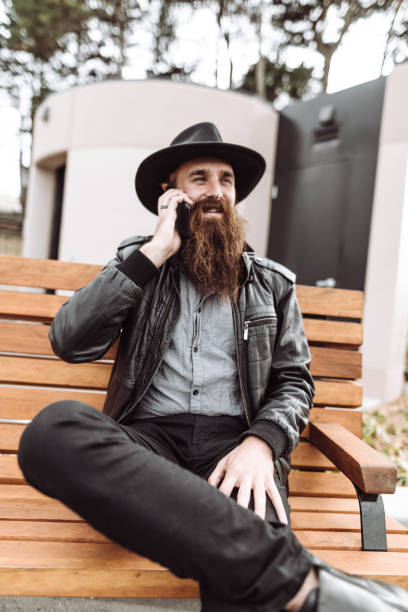 istock hipster with smartphone working in the park 1027638744