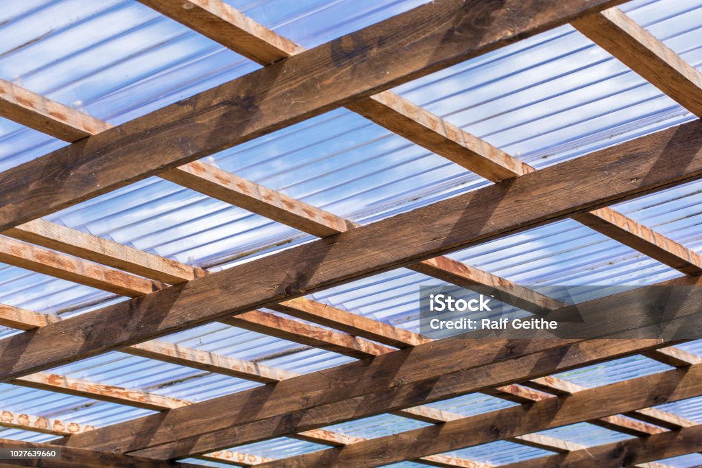 Roof construction of a self-made carport made of wooden beams and transparent roof panels roof constructions Rooftop Stock Photo