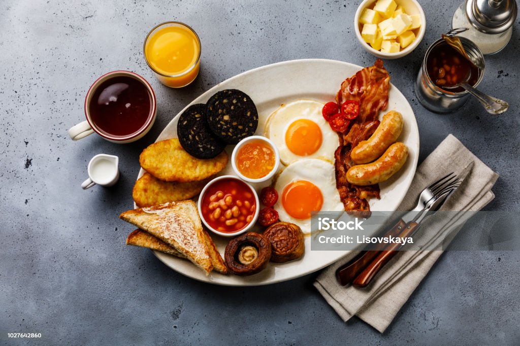 Volle Braten, englisches Frühstück mit Spiegelei, Würstchen, Speck, Blutwurst, Bohnen, Toast und Tee - Lizenzfrei Frühstück Stock-Foto