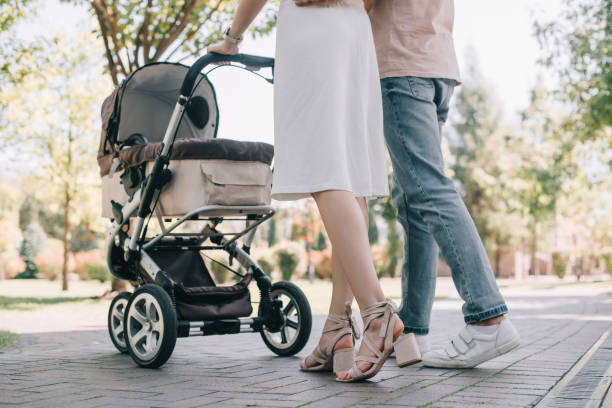 cortada a imagem dos pais andar com carrinho de bebê no parque - carriage - fotografias e filmes do acervo