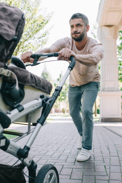 istock father pushing heavy baby carriage in park 1027646492