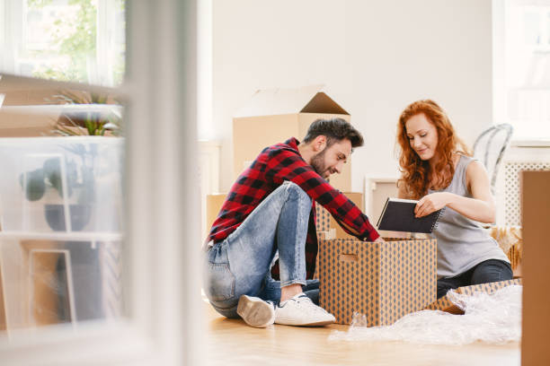 istock Man and woman unpacking stuff after relocation to new home 1027649400