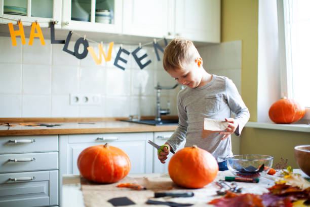 mały chłopiec przygotowuje się do halloween - house halloween autumn candid zdjęcia i obrazy z banku zdjęć