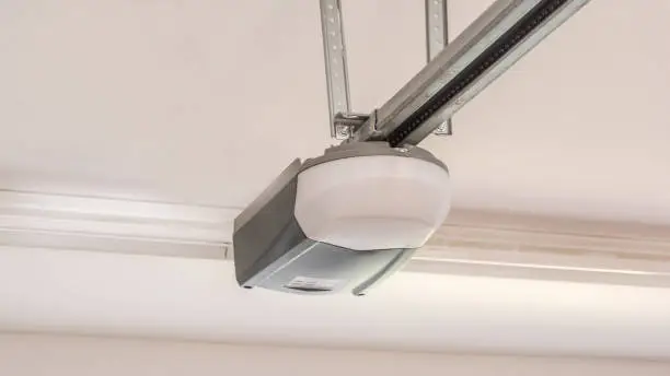 Photo of Automatic Garage Door Opener Motor on the Ceiling. Close Up.