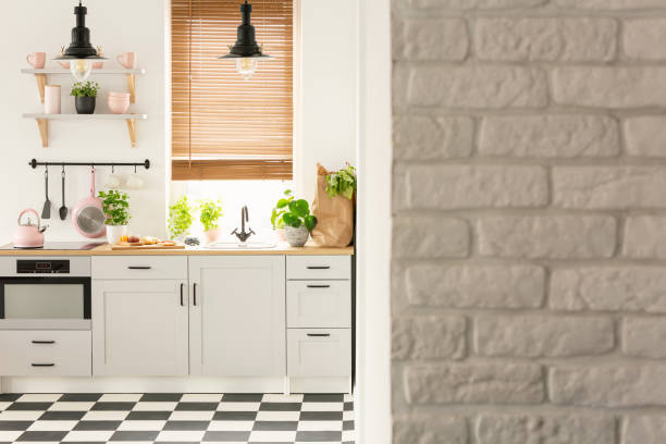 istock Grey brick wall in bright kitchen interior with lamps above coun 1027660236
