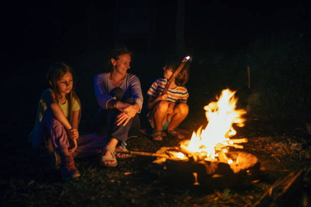 istock Mother sitting next to the campfire with her children 1027673798