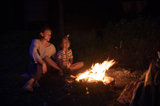 istock Mother sitting next to the campfire with her child 1027673802