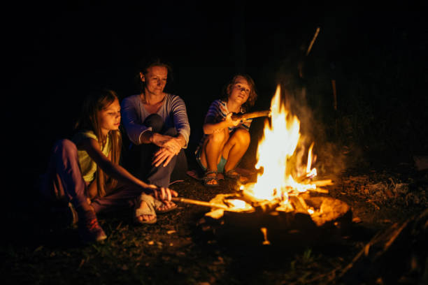 istock Mother sitting next to the campfire with her children 1027674052