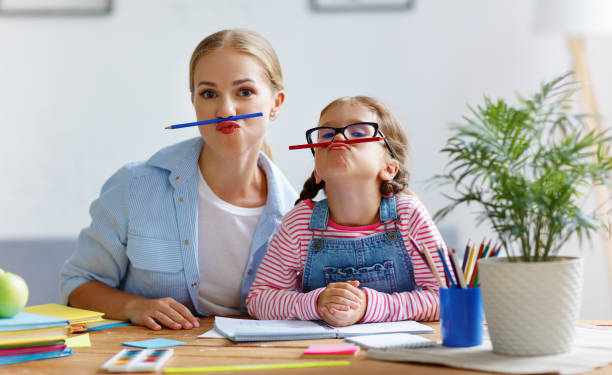 istock funny mother and child daughter doing homework writing and reading 1027674254