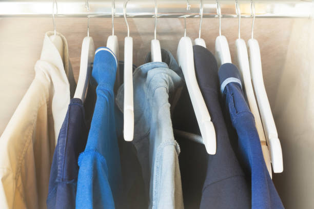 istock Blue and gray t-shirts on hangers in the closet. Rendered image. Selective focus. 1027674428