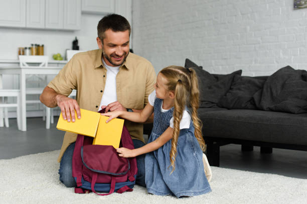 istock smiling father helping little daughter packing backpack for first day at school, back to school concept 1027677546