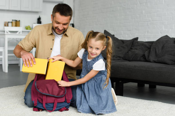 istock smiling father helping little daughter packing backpack for first day at school, back to school concept 1027677550