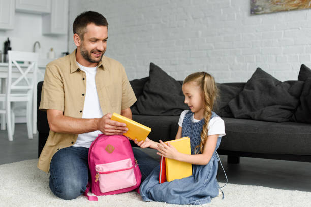 istock daughter and father packing backpack for first day at school, back to school concept 1027677602