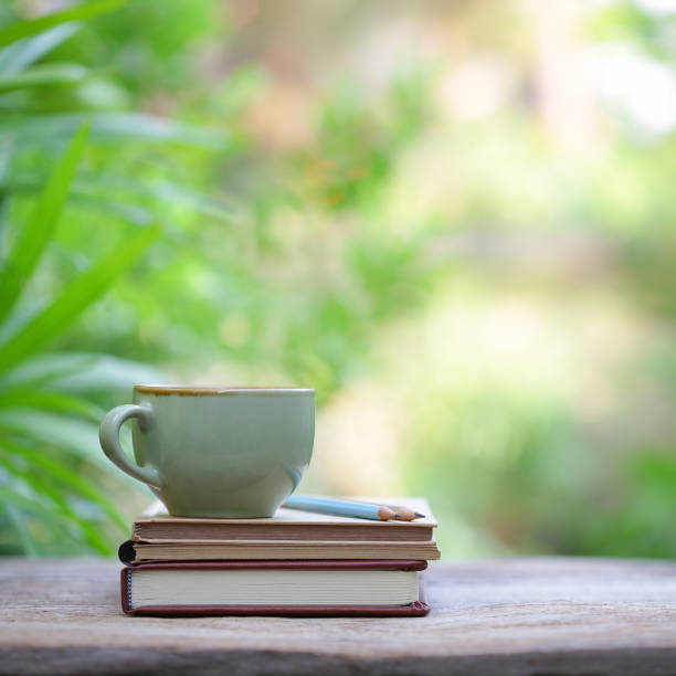 istock vintage green cup and old books on wooden table 1027686466
