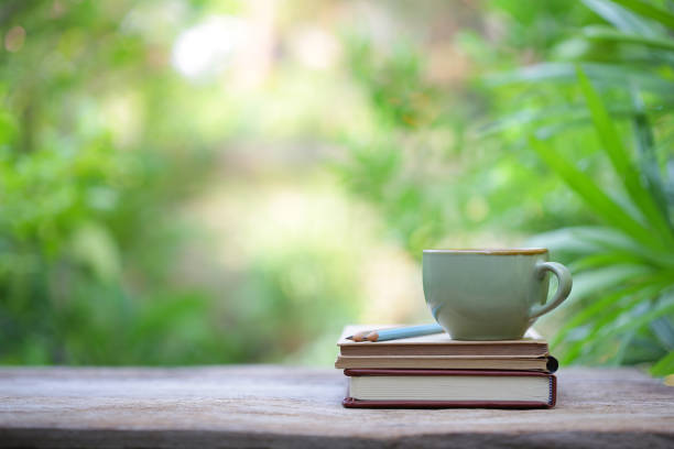 istock vintage green cup and old books on wooden table 1027686502