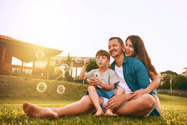 rien ne dit s’amuser en famille comme soufflant des bulles - bubble wand outdoors little boys mother photos et images de collection