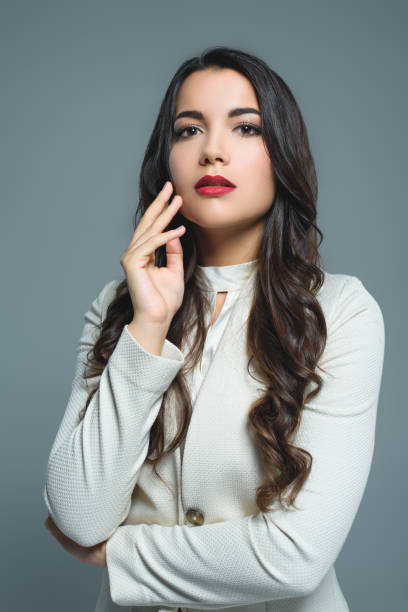 istock stylish brunette girl posing in white suit, isolated on grey 1027693248