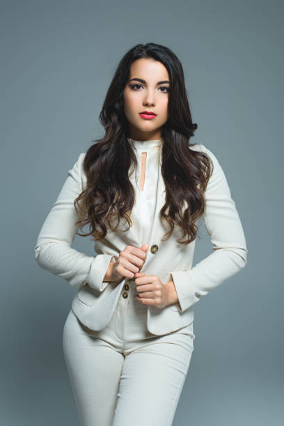 istock beautiful elegant woman in white suit, isolated on grey 1027693538