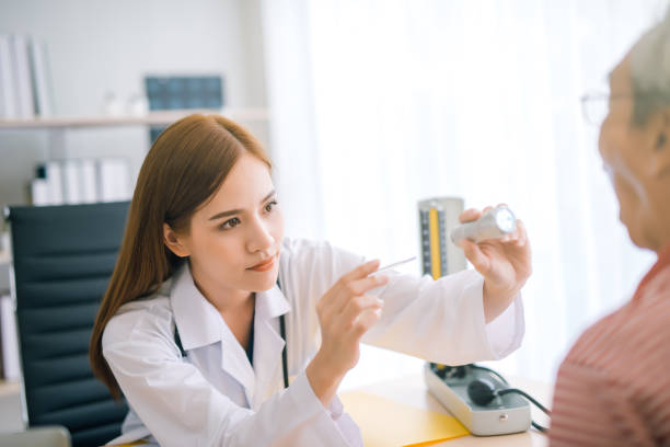 istock young female Asian doctor checking a patients throat 1027693608