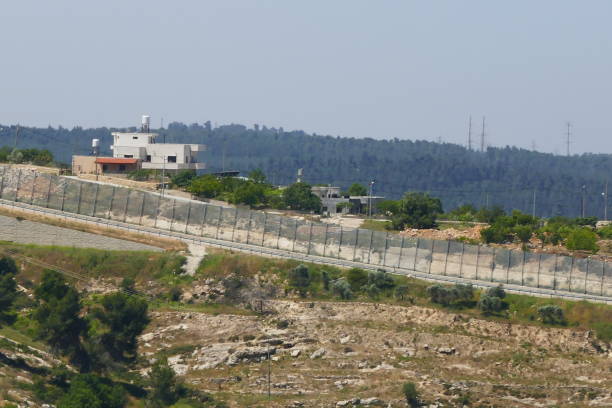 istock Barren hillside with the Bethlehem Wall with apparently deserted buildings from Jerusalem 1027697042