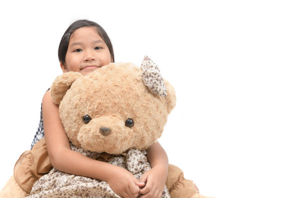 istock Cute girl hugging big teddy bear isolated 1027697194