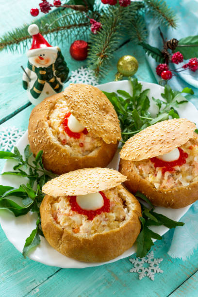 istock Festive appetizer on the Christmas table. Bun stuffed with shrimp salad and red caviar. 1027697770