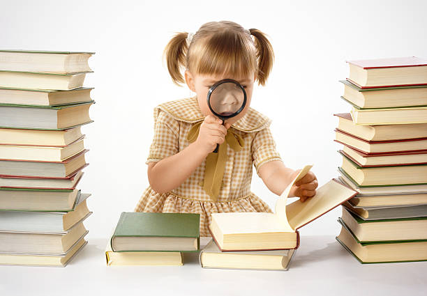 istock Little girl looking at book through magnifier 102769801