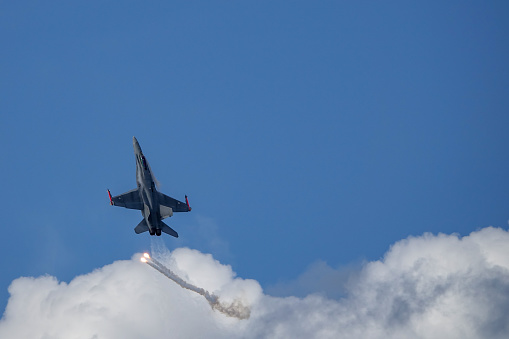 Uppsala, Sweden - August 25, 2018: McDonnell Douglas F-18 Hornet,  multirole combat jet fighter. Releasing decoy flare (countermeasure). Air show.