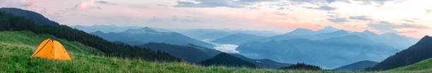 istock Orange tourist tent on the plain among the mountains 1027712218