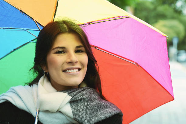 istock Beautiful woman under rainbow umbrella 1027718556