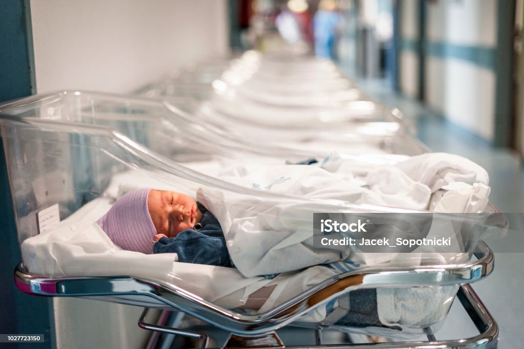 Newborn baby in first of many small hospital beds Newborn baby boy in his small transparent portable hospital bed Hospital Stock Photo