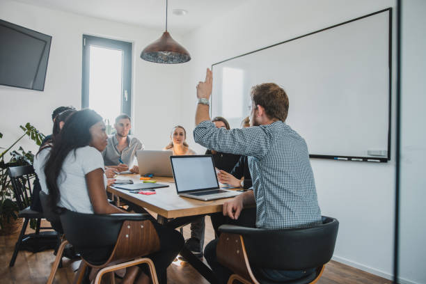 istock Businessman asking a question with raised hand in the conference room 1027724152
