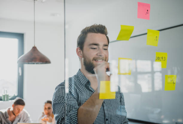 istock Man writing on adhesive notes during a business meeting 1027724218