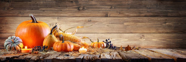 istock Thanksgiving Background - Pumpkins With Corncob And Candles On Rustic Wooden Table 1027730652
