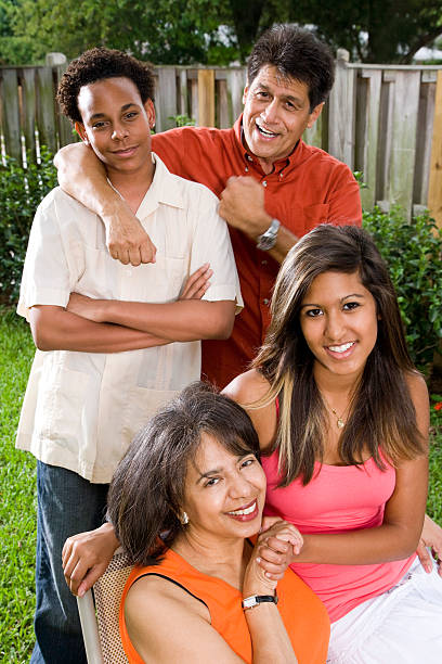 Guatemalan mother and African American father with two children family photo in park.