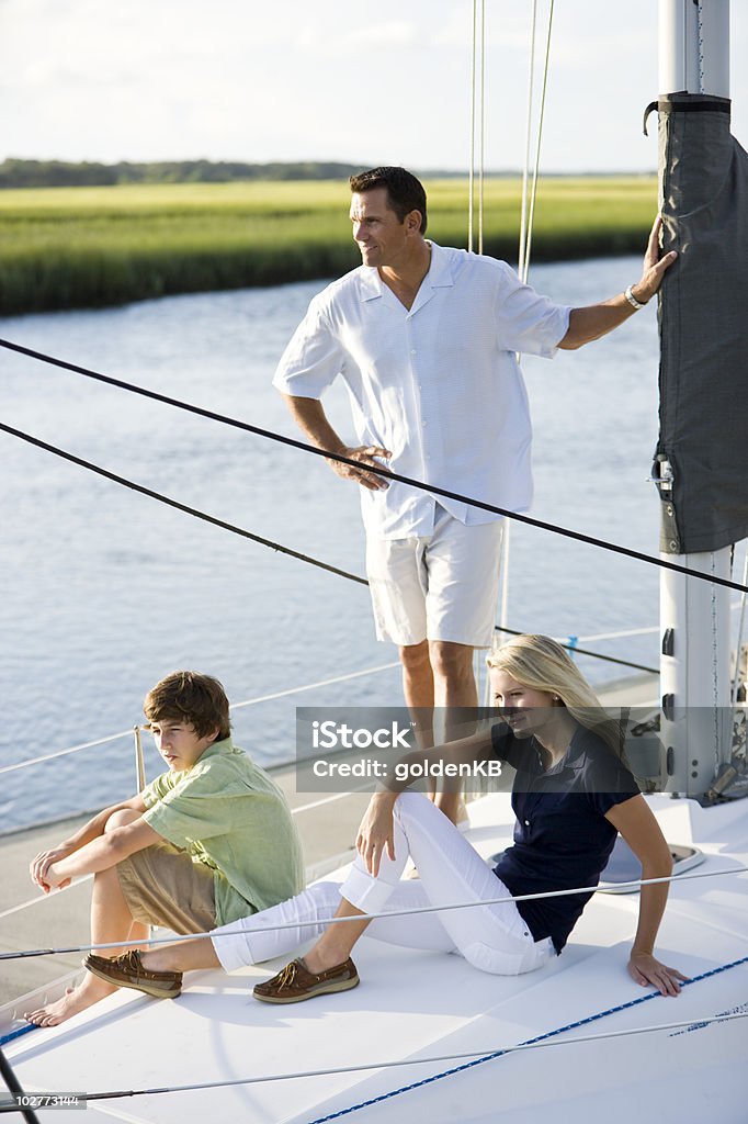 Pais e dois filhos adolescentes no barco relaxante - Foto de stock de 14-15 Anos royalty-free