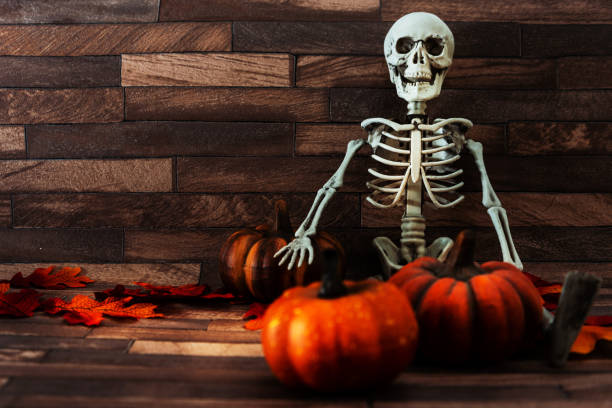 istock Halloween concept with a pumpkin and skeleton on background 1027739140