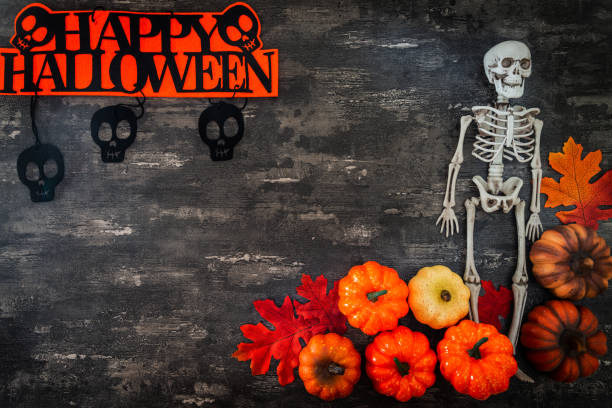 istock Halloween concept with a pumpkin and skeleton on background 1027739168