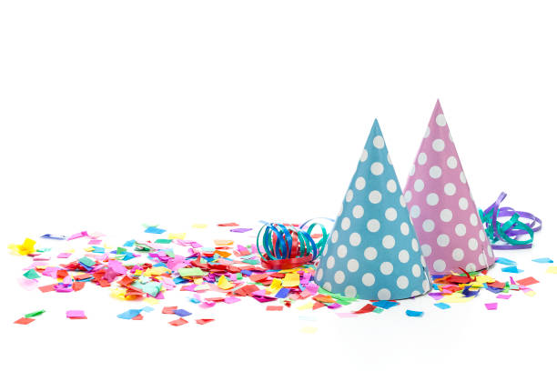 Carnival or party background. Front view of multi colored paper confetti and party hats background shot on white backdrop. High key DSRL studio photo taken with Canon EOS 5D Mk II and Canon EF 100mm f/2.8L Macro IS USM.