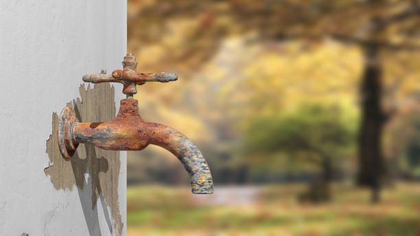 istock 3D old rusty outside water tap, with blurred nature background 1027745326