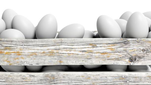 White eggs in old wooden container closeup, isolated on white.