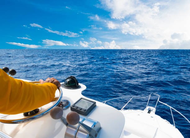 mano del capitano sul volante della barca a motore nell'oceano blu durante la giornata della pesca. concetto di pesca di successo. yacht oceanico - barca da diporto foto e immagini stock