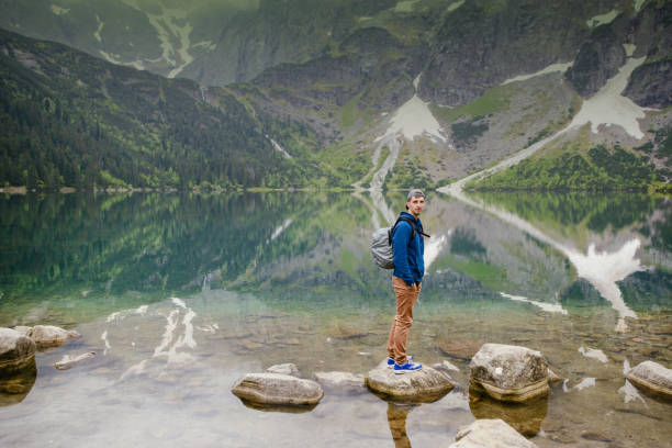 istock man relaxing on the lake and mountains sunny landscape 1027746922