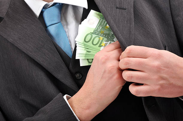 istock Businessman putting a stack of banknotes in his jacket 102775683
