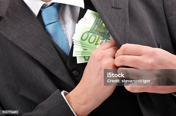 Businessman Putting A Stack Of Banknotes In His Jacket Stock Photo - Download Image Now